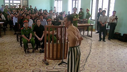 Ông Huỳnh Văn Nén cởi áo, chỉ những vết sẹo mà ông nói là do bị đánh trong tù, tại phiên tòa phúc thẩm (lần 3) “Vụ án vườn điều” ngày 9/3/2005. Ảnh: Tiền phong.