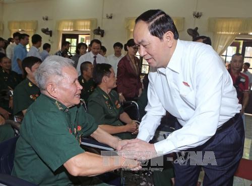 Chủ tịch nước Trần Đại Quang ân cần thăm hỏi các thương binh, bệnh binh. ảnh: TTXVN.