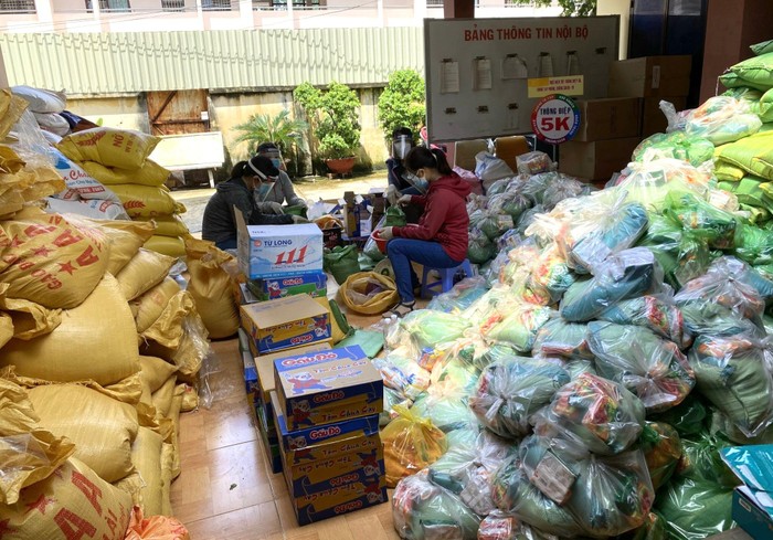 Tập thể giáo viên trường tiểu học Phú Hòa 3 (Bình Dương) phân chia nhu yếu phẩm để phân phát cho bà con trong khu phong tỏa. Ảnh: NVCC.