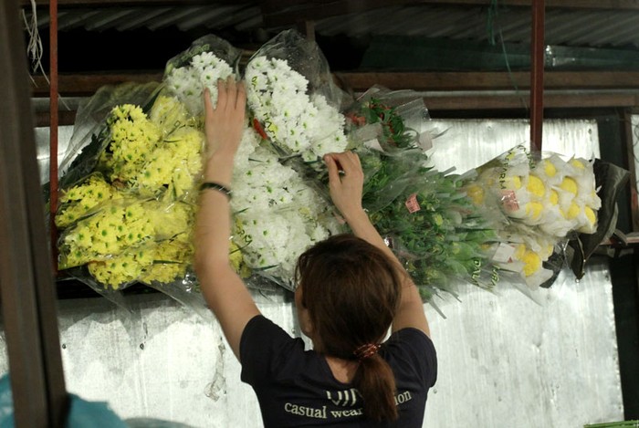 Sắp sếp ngay ngắn những bó hoa đợi khách đến mua.