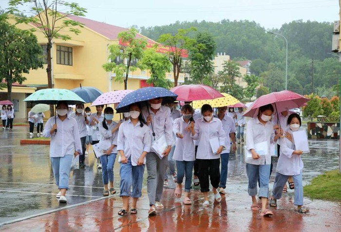 Các thí sinh che ô đến Điểm thi Trường Trung học phổ thông Hoành Bồ (Ảnh: CTV)