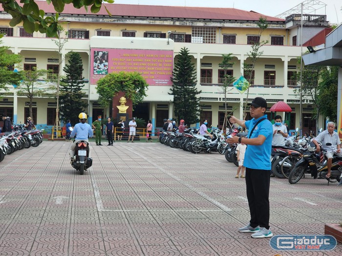 Đội thanh niên xung kích hướng dẫn phụ huynh đỗ xe đúng nơi quy định (Ảnh: Phạm Linh)