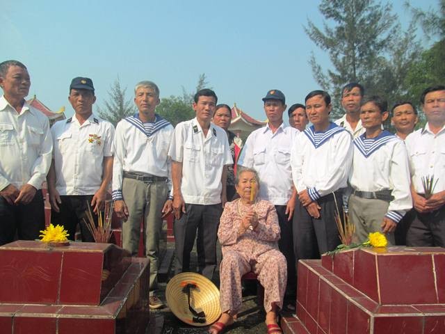 Những cựu binh Gạc Ma và mẹ Hồ Thị Đức thắp hương tưởng nhớ đồng đội. (Ảnh: X.T)