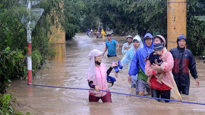 Người nhà các học trò Trường mẫu giáo An Hiệp, huyện Tuy An (Phú Yên) vui mừng đón con em mình sau khi được các cô giáo cứu thoát - Ảnh: NGỌC THẮNG/Báo Tuổi trẻ.