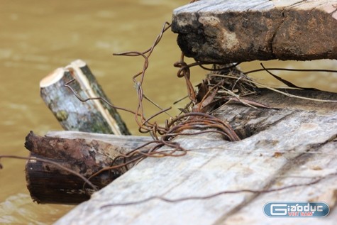 Cây cầu tạm bắc qua suối được ghép bằng những mảnh ván, chằng néo sơ sài. Ảnh: Xuân Quang.