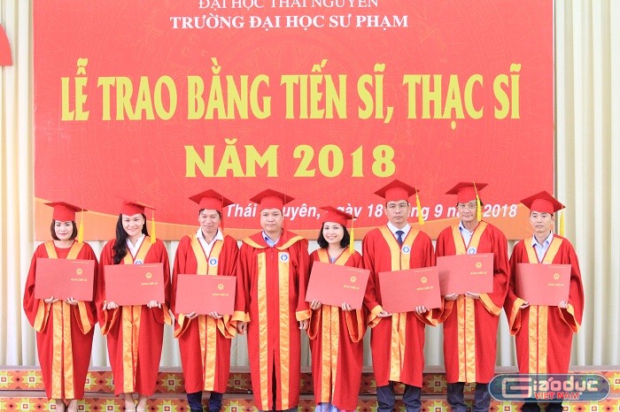 Các tân tiến sĩ chụp ảnh lưu niệm cùng lãnh đạo nhà trường. Ảnh của Xuân Quang.