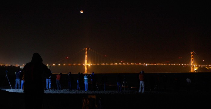 Người dân đứng xem nguyệt thực ở tháp phía Bắc của cầu Cổng Vàng, San Francisco, Mỹ.