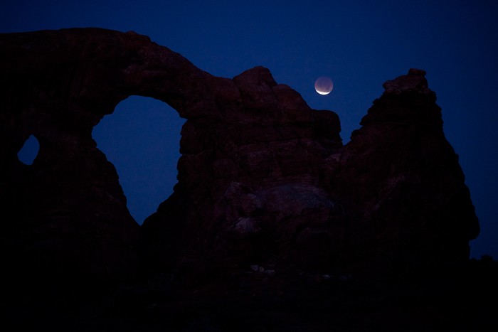 Hình ảnh nguyệt thực bên trên vòm đá Turret Arch, ở công viên quốc gia Arches, gần Moab, Utah.