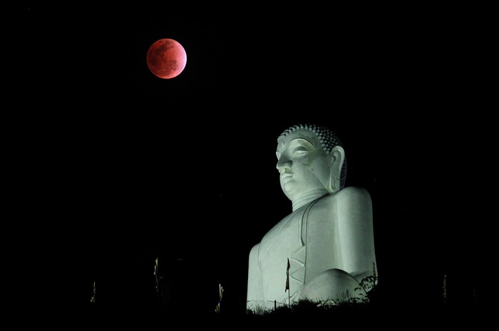 Nguyệt thực nhìn thấy trên bầu trời bên một bức tượng Phật ở Kurunegala, Sri Lanka.