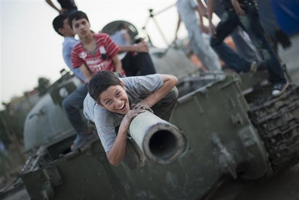 Nụ cười của cậu bé khi đang chơi trên một chiếc xe tăng tại một cuộc triển lãm nhằm kỷ niệm cuộc chiến tranh Iraq-Iran.