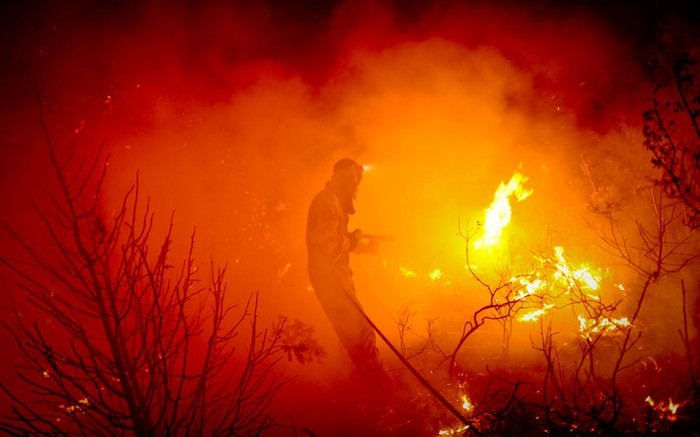 Một lính cứu hỏa cố gắng dập tắt một đám cháy rừng ở El cubillo de Uceda, tỉnh Guadalajara.