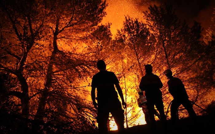 Các nhân viên cứu hỏa cố gắng dập tắt một đám cháy rừng ở Torre de Macanes gần Alicante.