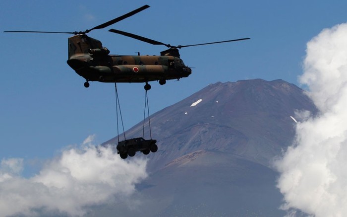 Trực thăng CH-47J Chinook đang chở một chiếc xe bọc thép gần núi Phú Sĩ.