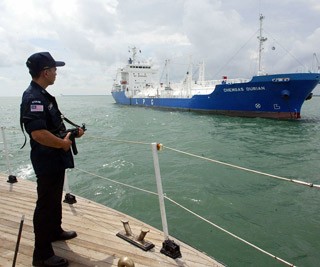 Cảnh sát biển có vũ trang của Malaysia đang đứng canh trên tàu tuần tra ở eo biển Alacca.