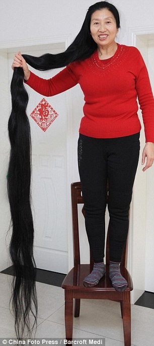 Bà Ni Linmei phải đứng trên ghế cao để đo độ dài của tóc