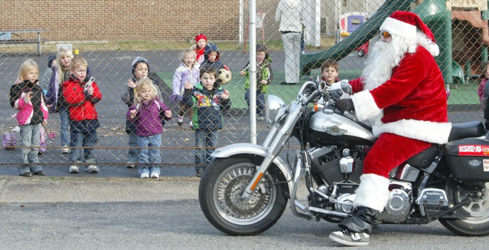 Có lẽ những đứa trẻ bên kia hàng rào đang tự hỏi sao ông già Noel lại đi xe máy thay vì cưỡi tuần lộc?. Ảnh ngày 1/12/2011