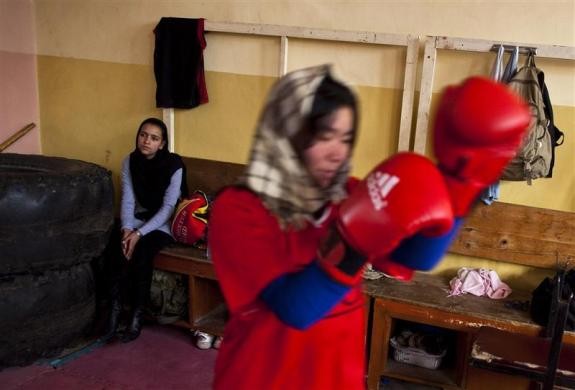 Một khách thăm quan và nữ vận động viên đấm bốc Afghanistan đang tập luyện trong câu lạc bộ ở Kabul ngày 28/12