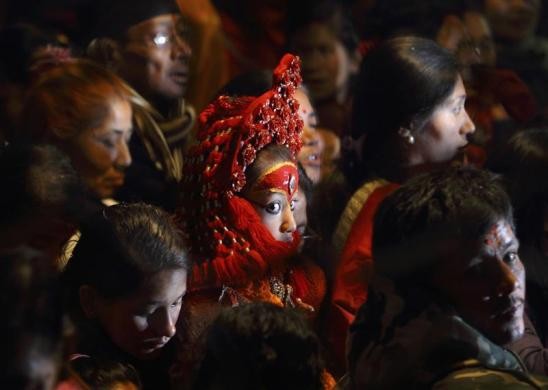 Các tín đồ vây quanh Nữ thần sống Kumari (giữa) trong nghi lễ tắm của Chúa Machindranath ở Kathmandu ngày 1/1. Những người được chọn làm Kumari là các trinh nữ còn 1 năm nữa mới tới tuổi dậy thì. Thần Kumari được cả người Hindu và Phật giáo tại Nepal tôn thờ. Các Kumari được chọn khoảng 12 lần trong năm vào những dịp tổ chức các nghi lễ tôn giáo. Người Nepal cầu nguyện Chúa Machindranath để xin ban mưa và thu hoạch tốt.