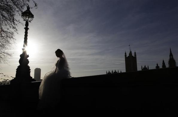 Một cô dâu ngồi trên bức tường đối diện tòa nhà Quốc hội ở London trong quá trình chụp ảnh cưới ngày 6/1
