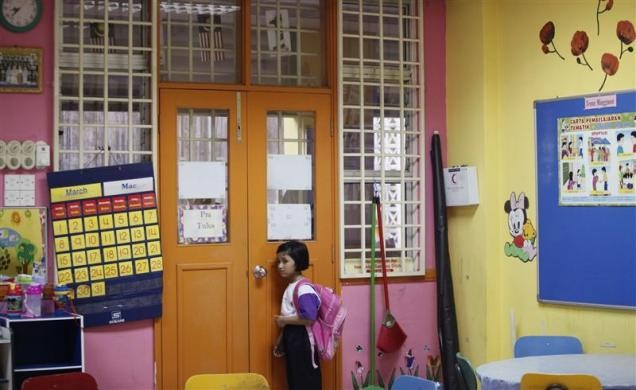 Nuranisya Alihasdi, 6 tuổi, từ chối hòa nhập với các bạn và lẻn sang phòng khác đứng một mình trong ngày đầu tiên tới trường ở Putrajaya, ngoại ô Kuala Lumpur, Malaysia ngày 4/1