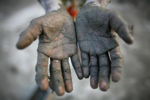 Tota Miya, 10 tuổi, khoe bàn tay lấm đầy đất đen của mình sau khi làm đất để chuẩn bị đóng gạch tại nhà máy gạch ở ngoại ô Dhaka ngày 21/11/2009.