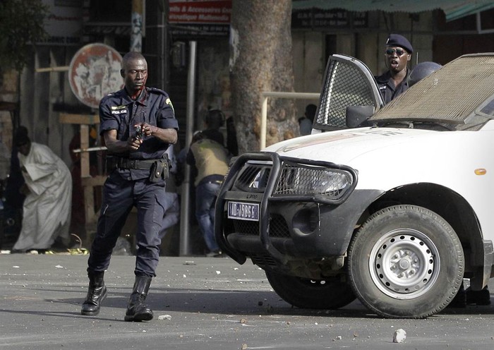 Cảnh sát nổ súng sau khi bị những người biểu tình chống chính phủ ném đá vào đầu tại Dakar, Senegal ngày 17/2.