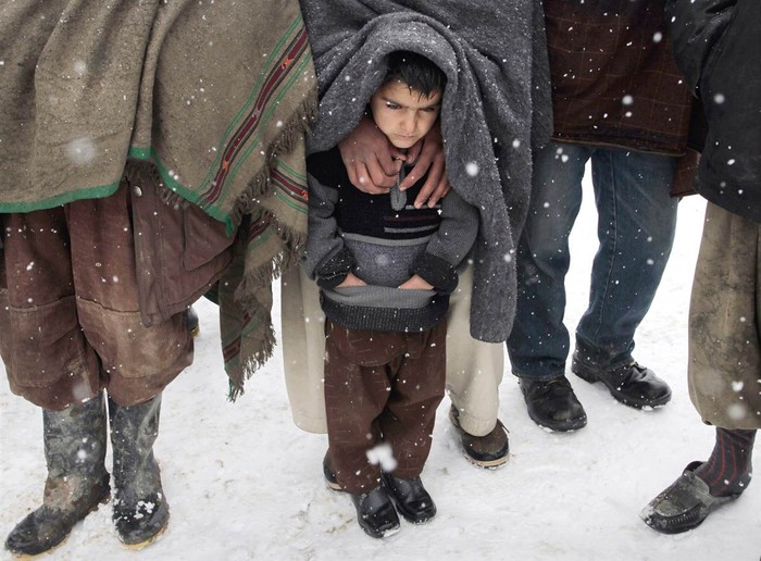 Một em bé Afghanistan co ro trong giá lạnh chờ để nhận được chăn và áo khoác từ một tổ chức cứu trợ của Đức tại Kabul.