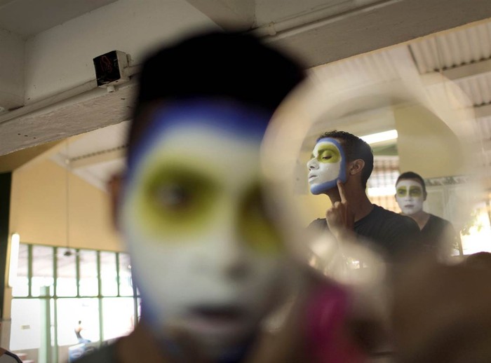Một cậu bé cầm gương trong quá trình hóa trang tham gia carnival Barranquilla ở Barranquilla, Colombia vào ngày 18/2.