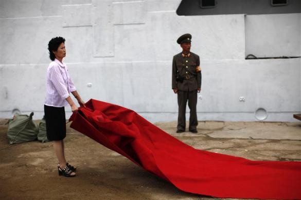 Một phụ nữ trải thảm đỏ chuẩn bị đón khách lên tàu du lịch Mangyongbyong tại đặc khu kinh tế Bắc Triều Tiên ở thành phố Rason, phía đông bắc của Bình Nhưỡng ngày 30/8/2011.