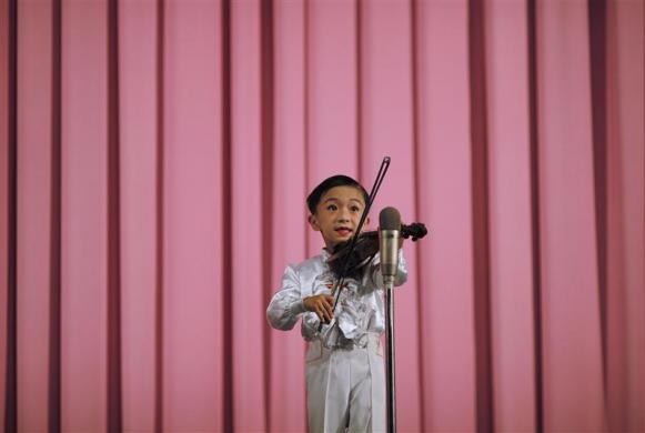 Một cậu bé hạnh phúc và hãnh diện khi được trổ tài âm nhạc trước đám đông trong khán phòng ở Rajin ngày 29/8/2011.