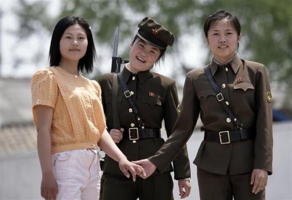 Một cô gái và các nữ quân nhân Triều Tiên nhìn về phía Trung Quốc từ khu vực biên giới Yalu ngày 28/5/2009.