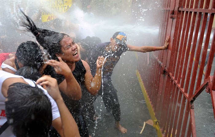 Các sinh viên biểu tình phản đối sự thô bạo của cảnh sát trong quá trình cưỡng chế dỡ bỏ những ngôi nhà xây lấn chiếm đất bị phun pháo nước tại khu vực biểu tình gần cung điện Malacanang ở Manila, Philippines ngày 25/4.