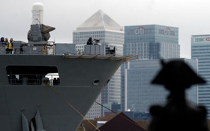 Bóng bức tượng Horatio Nelson khi tàu HMS Ocean vượt qua Canary Wharf.