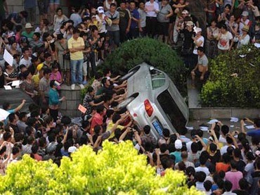 Người biểu tình môi trường lật đổ xe công vụ trước cửa trụ sở chính quyền thành phố Qidong.