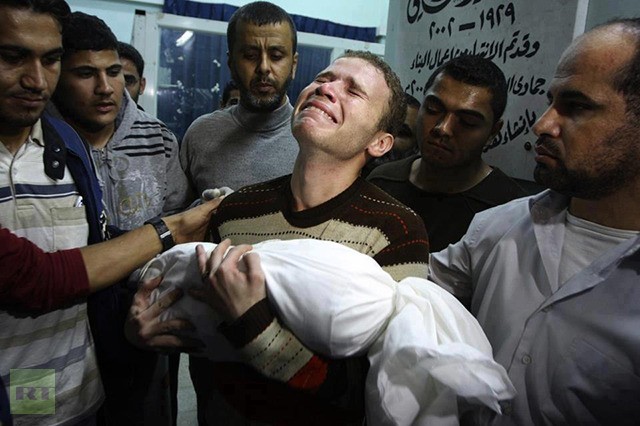 Phóng viên BBC Jihad Masharawi ôm đứa con trai 11 tháng tuổi thiệt mạng do tên lửa Israel. Em dâu và em trai của anh cũng đã bị thương trong các cuộc tấn công này.