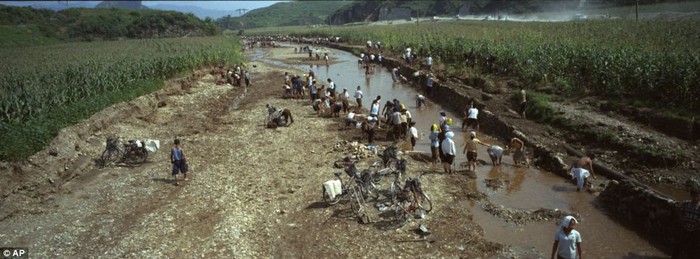 Người dân tu sửa lại con kênh dẫn nước gần cánh đồng ngô bị hư hỏng do trận lũ lụt tháng 7 tại huyện Songchon.