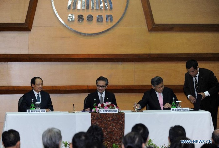 Cựu Tổng thư ký ASEAN Surin Pitsuwan (thứ 2 từ phải sang) ký văn bản chuyển giao nhiệm vụ cho tân Tổng thư ký Lê Lương Minh (ngoài cùng bên trái) và Bộ trưởng Ngoại giao Indonesia Marty Natalegawa (thứ 2 từ trái sang) đại diện nước chủ nhà chứng kiến buổi lễ chuyển giao nhiệm vụ tại trụ sở ASEAN ở Jakarta.