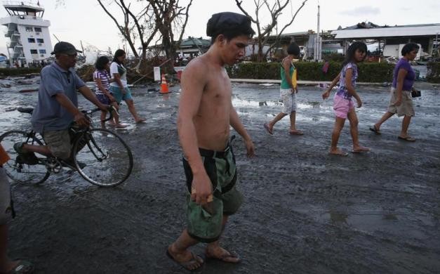 Người dân sống sót sau siêu bão đi bộ trên đường phố Tacloban