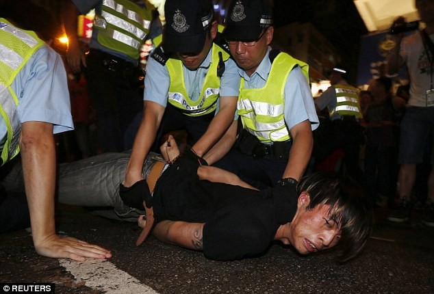 Cảnh sát bắt giữ một người biểu tình tham gia vào vụ ẩu đả.
