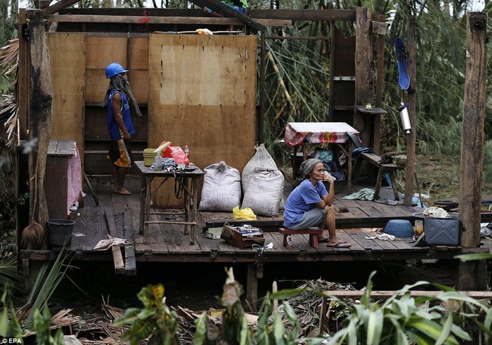 Người phụ nữ buồn rầu ngồi trong ngôi nhà đổ nát sau bão trên đảo Samar.