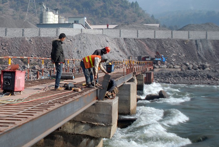 Một kỹ sư Trung Quốc đứng giám sát công nhân xây dựng một cây cầu ở Ghari Dopatta, Pakistan Kashmir. Nhiếp ảnh gia: Sajjad Qayyum / AFP / Getty Images.