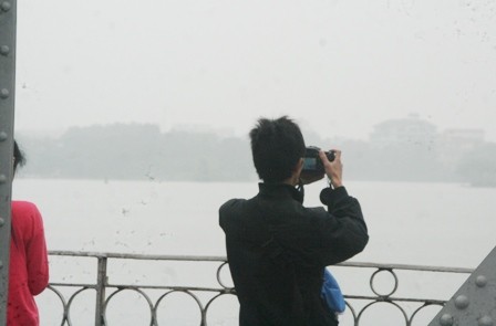 Khách du lịch thích thú chụp cảnh sương mù trên cầu Trường Tiền.