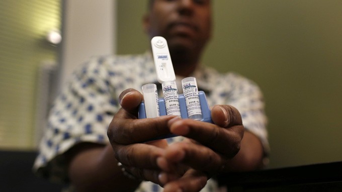 Một thành viên Trung tâm dịch vụ AIDS ở New York giới thiệu thiết bị xét nghiệm HIV nhanh - Ảnh: Reuters