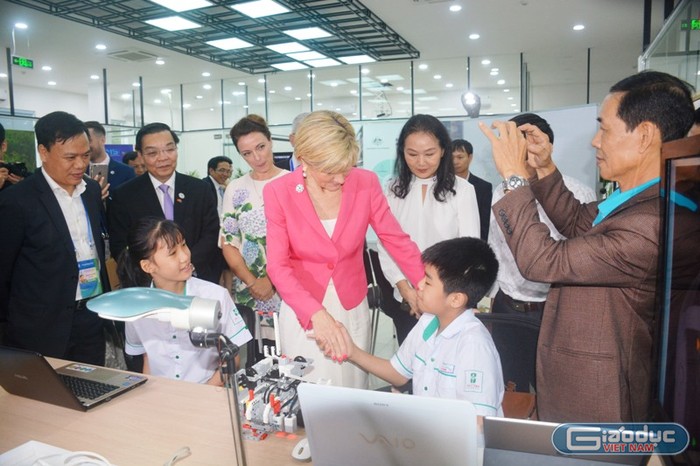 Bộ trưởng Bộ Ngoại giao và Thương mại Australia Julie Bishop (áo đỏ) bắt tay và nghe Khang giới thiệu về robot tự nâng. Ảnh: TT