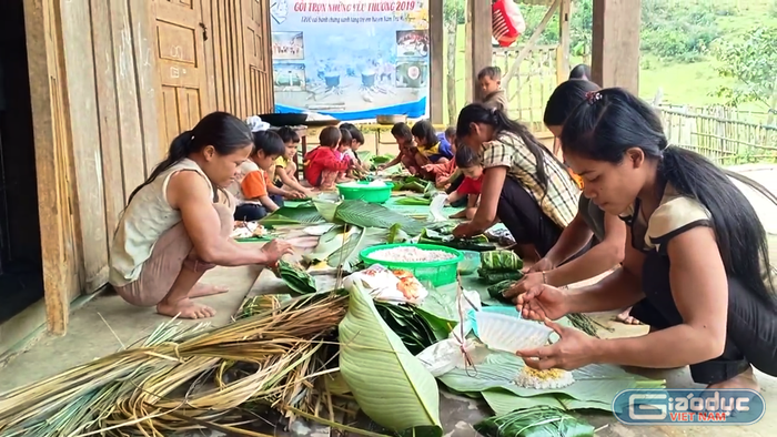 Phụ huynh, học sinh và giáo viên cùng nhau gói bánh.