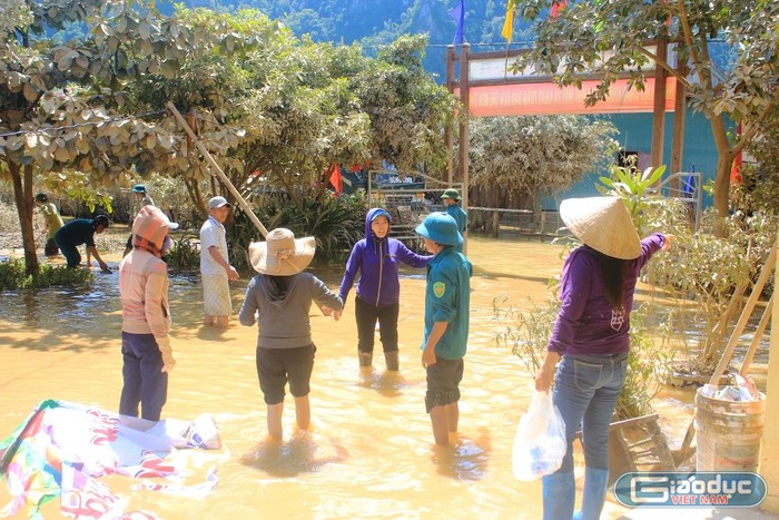 Các thầy cô lội nước lũ dọn trường.