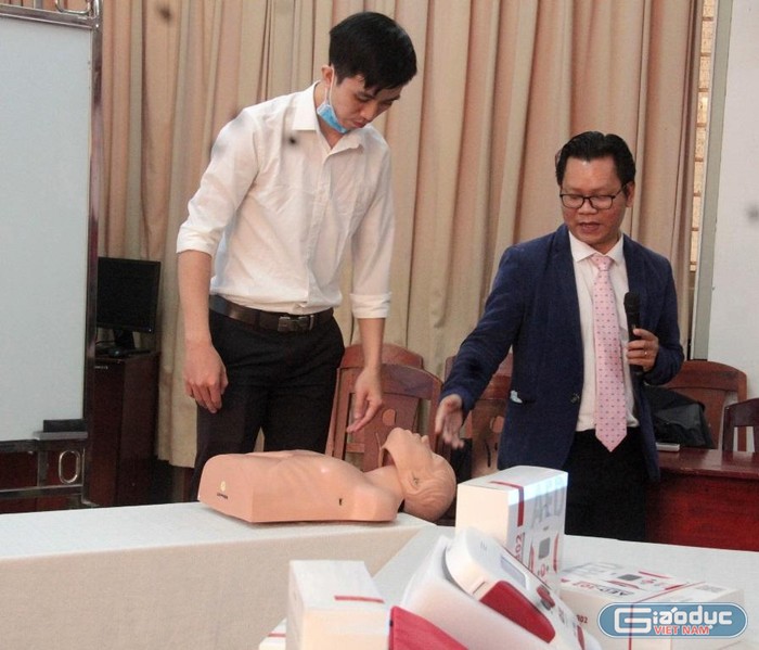 Thạc sĩ Lê Văn Chung cùng nhóm nghiên cứu chia sẻ về công năng của máy AED-302 Trainer dùng trong huấn luyện sơ cấp cứu đột quỵ. Ảnh: AN