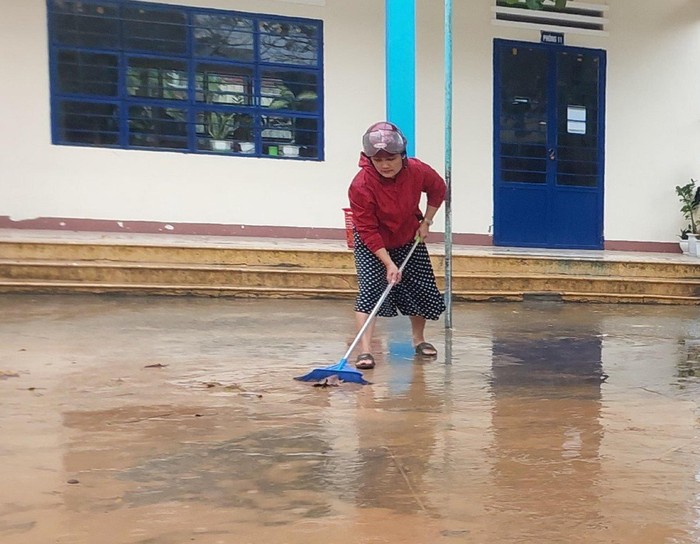 Giáo viên Trường tiểu học số 2 Hòa Liên dọn dẹp bùn đất sau khi nước rút. Ảnh: HG