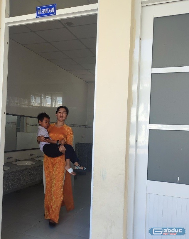 Giáo viên bồng học sinh bị mệt đi vệ sinh (Ảnh tác giả) gdvn-giáo viên bồng hs.jpg