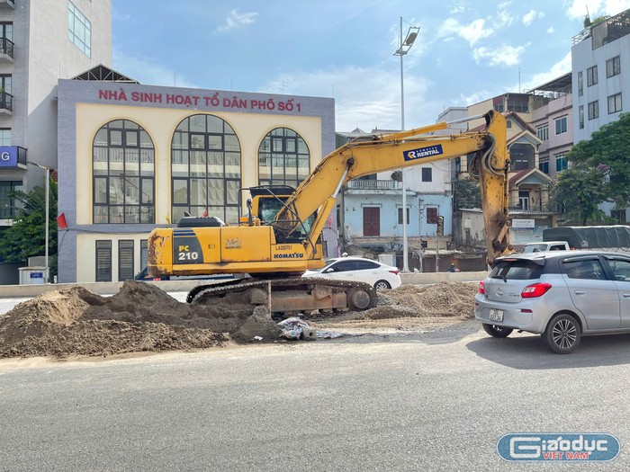 Máy xúc thực hiện việc san lấp và dọn dẹp vật liệu để công nhân thi công dải phân cách giữa. GDVN_21.jpg